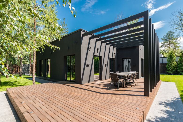 Terrasse en bois avec pergola autour d'une maison moderne