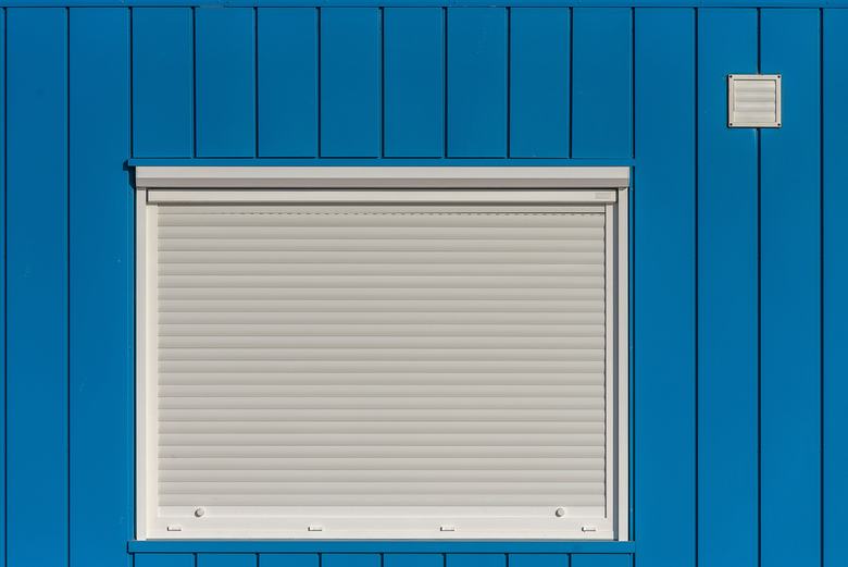 Volet roulant fermé sur une façade bleue